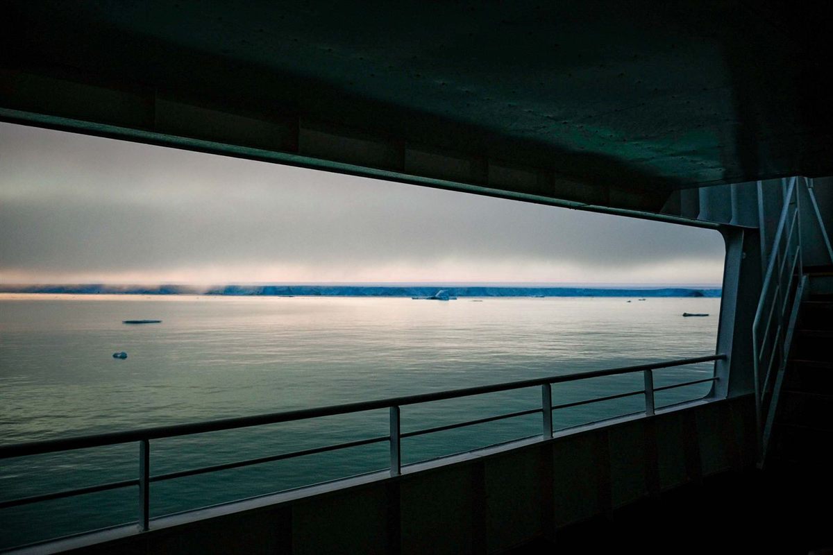 A quiet sea view framed by the open side of a ship’s deck