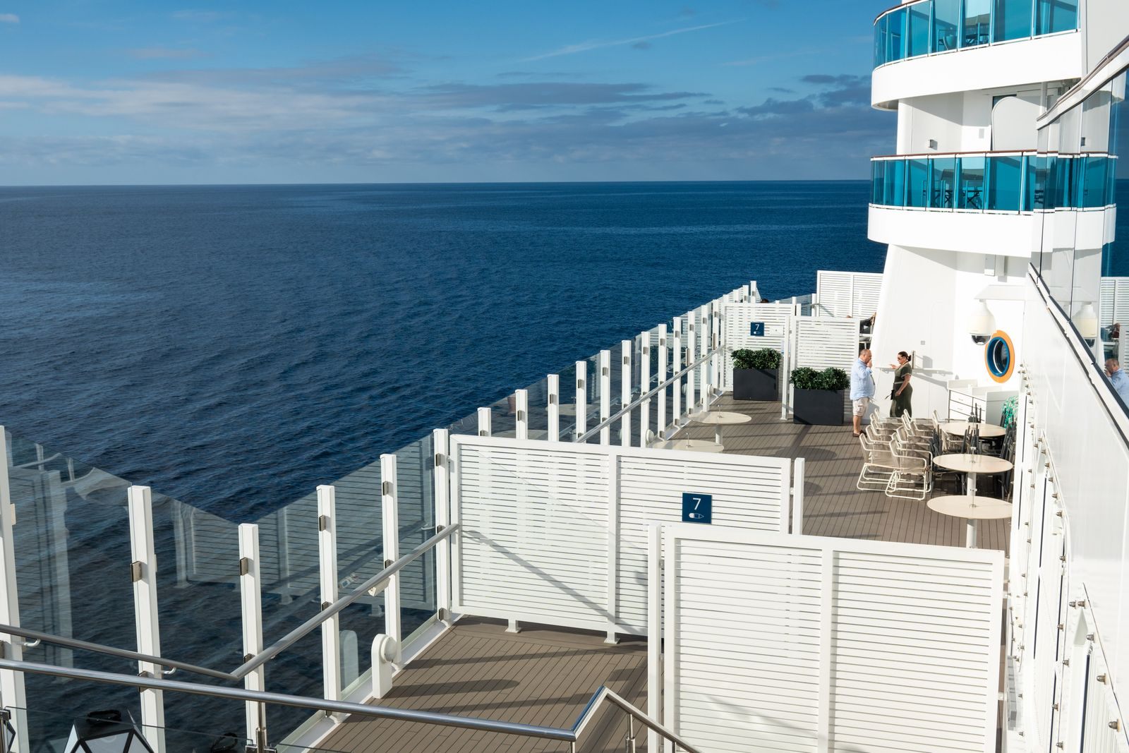 Private balcony terraces stepping down the side of a cruise ship above the open sea